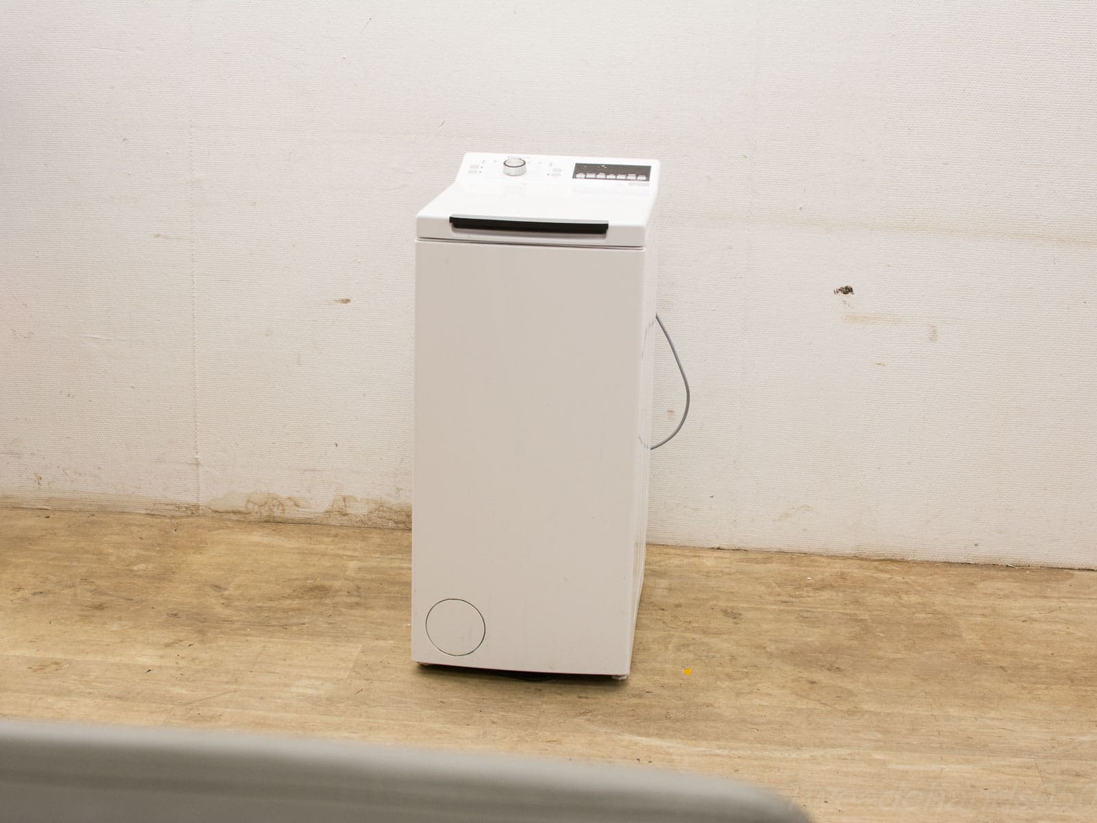 Compact white top-loading washing machine ideal for small spaces and effortless laundry tasks.