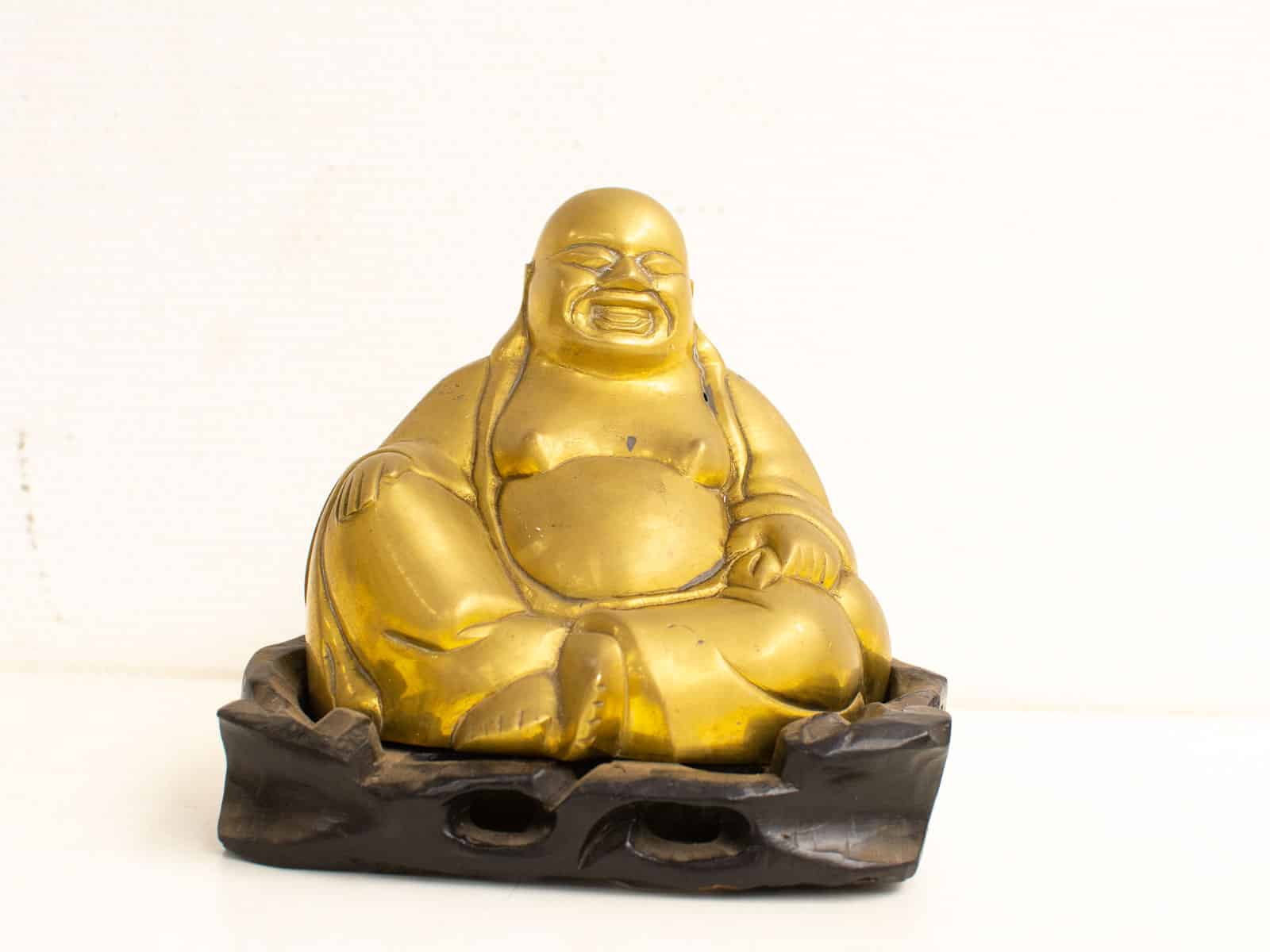 messing boeddha op een houten bankje  27583