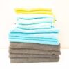 Colorful towel stack: bright yellow, soothing blues, and elegant gray for stylish bathrooms.