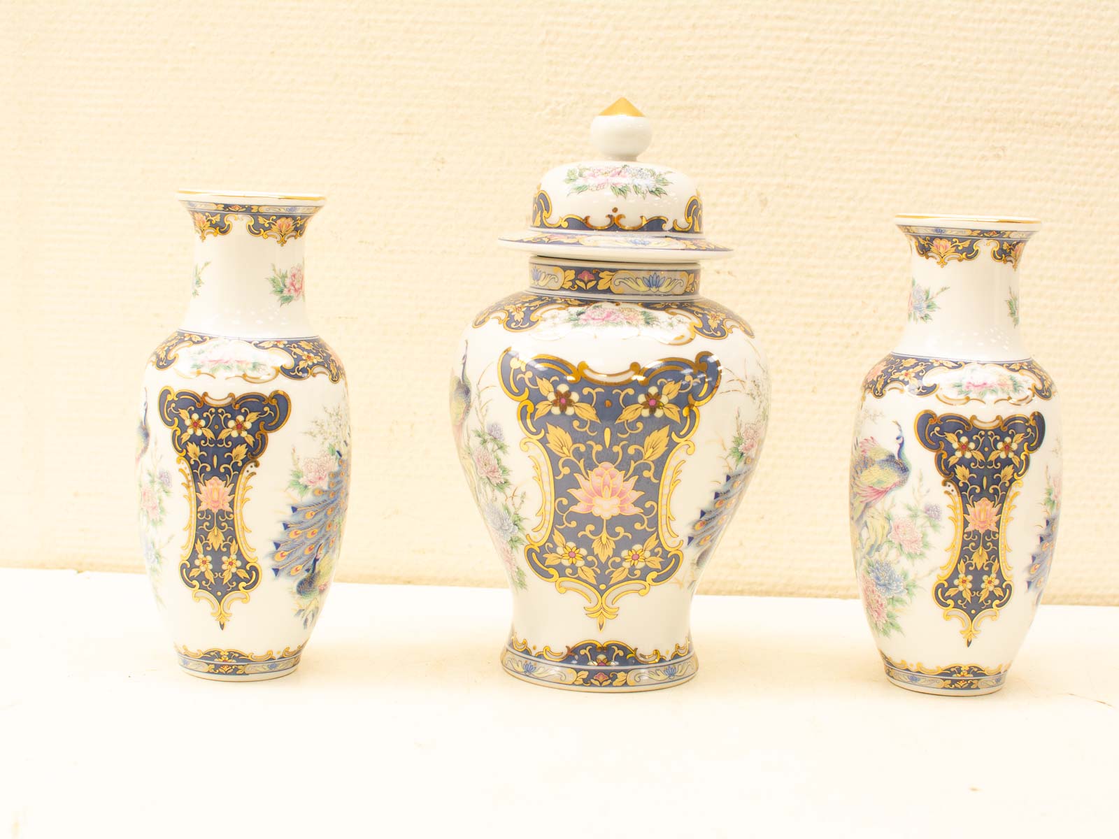 Exquisite trio of porcelain vases with floral designs and gold accents for elegant decor.