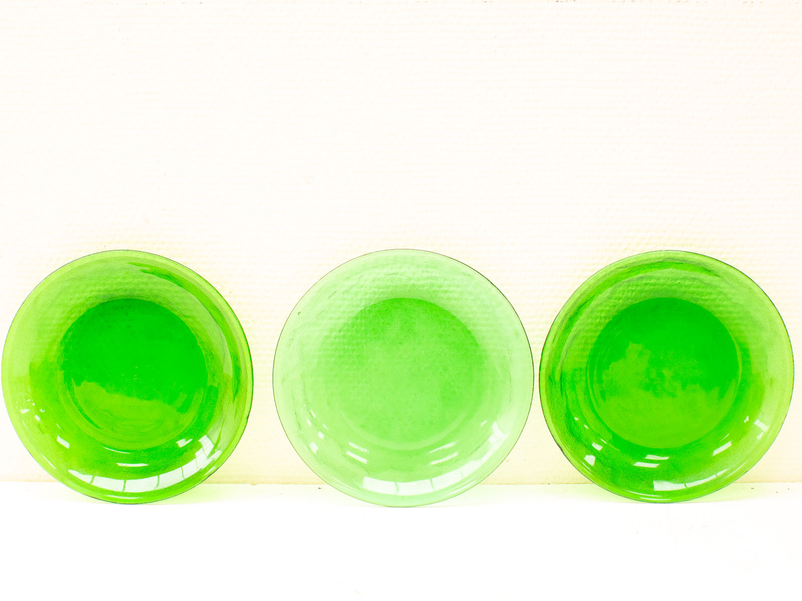 Glossy green plates arranged elegantly against a soft, neutral background for a striking visual impact.
