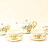 Elegant porcelain tea set with vibrant bird and floral designs, perfect for afternoon tea.