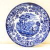 Elegant blue and white decorative plate showcasing a scenic landscape with horseback rider and floral border.