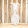 Elegant crystal vase with diamond cuts, set against a rustic wooden background. Perfect for decor.