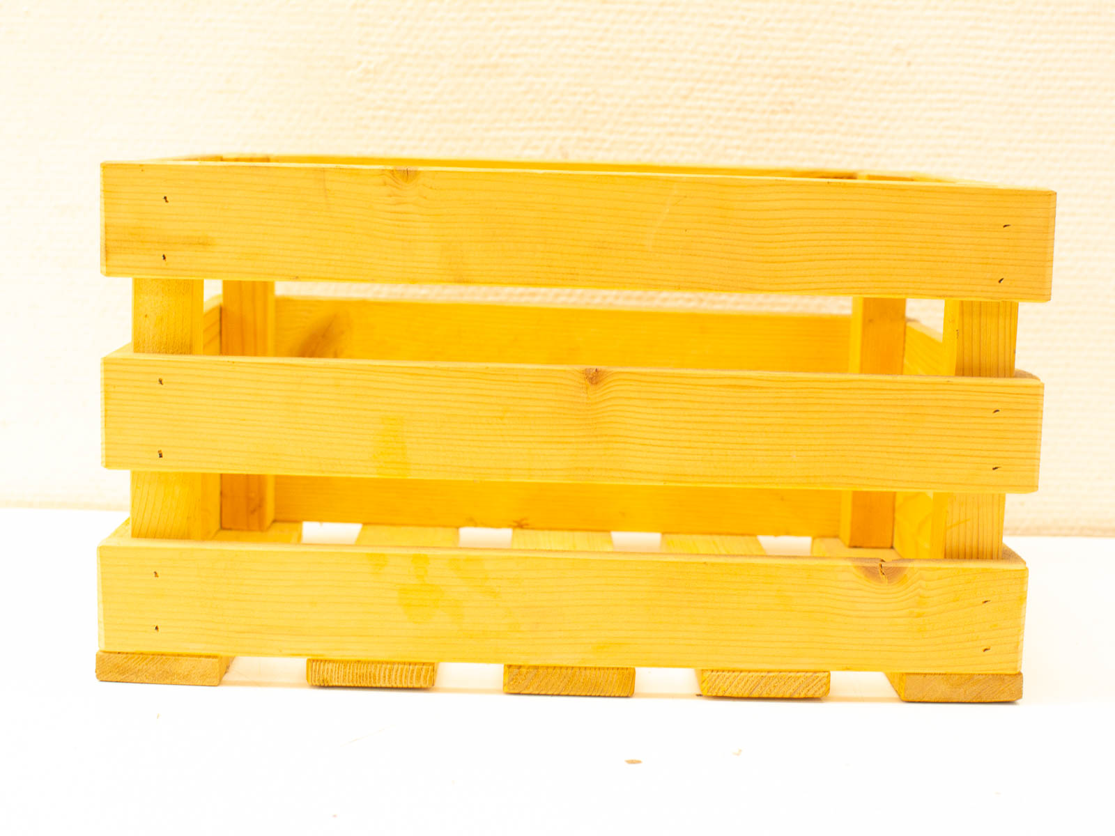 Bright yellow wooden crate for stylish storage of fruits, vegetables, or decorative items.