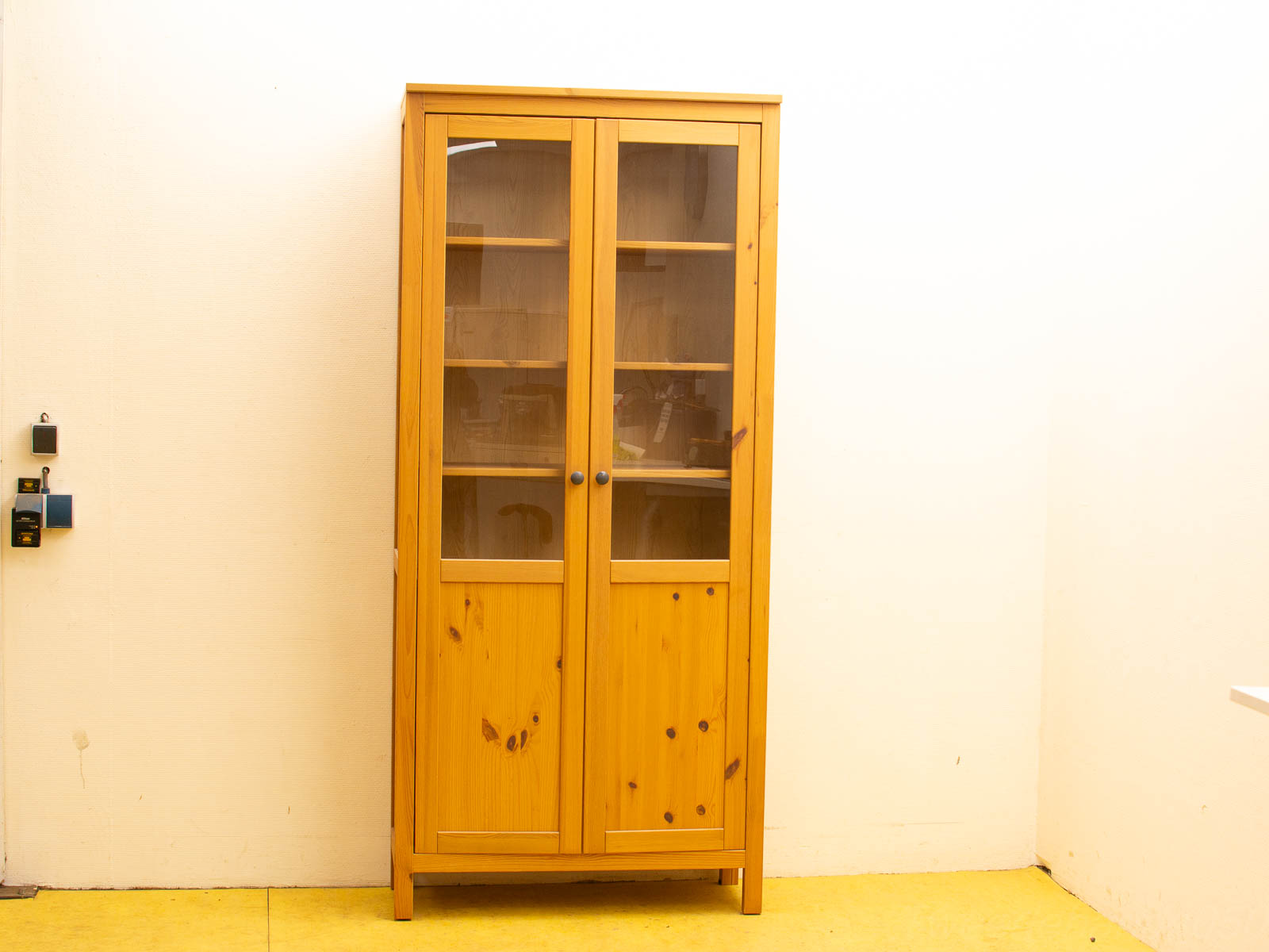 Elegant pine cabinet with glass doors for display and solid doors for hidden storage.