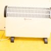 Sleek white and black indoor electric heater with safety vents for efficient warmth.