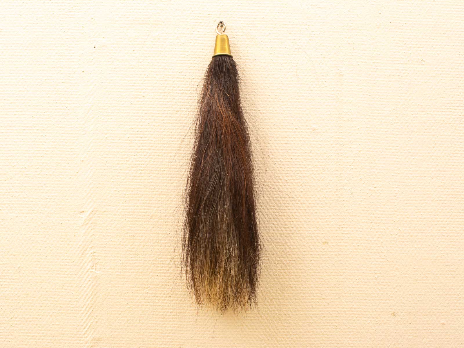 Elegant hair tuft with gold hanger, featuring a stunning brown to blonde ombre gradient.