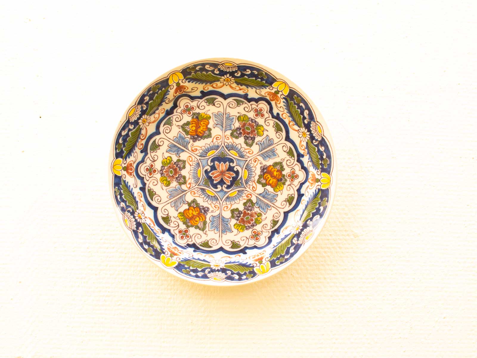 Vibrant vintage decorative plate with intricate floral designs, perfect for enhancing any space.