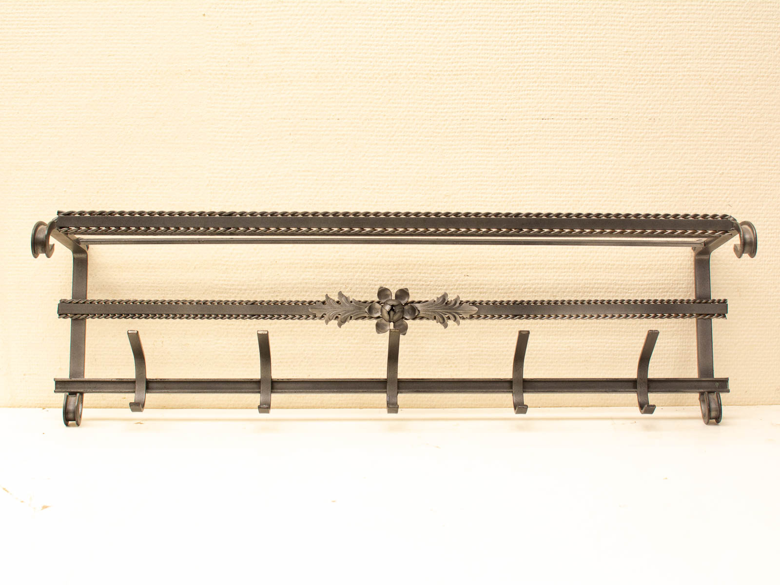 Elegant vintage wrought iron wall rack with six hooks for stylish storage solutions.
