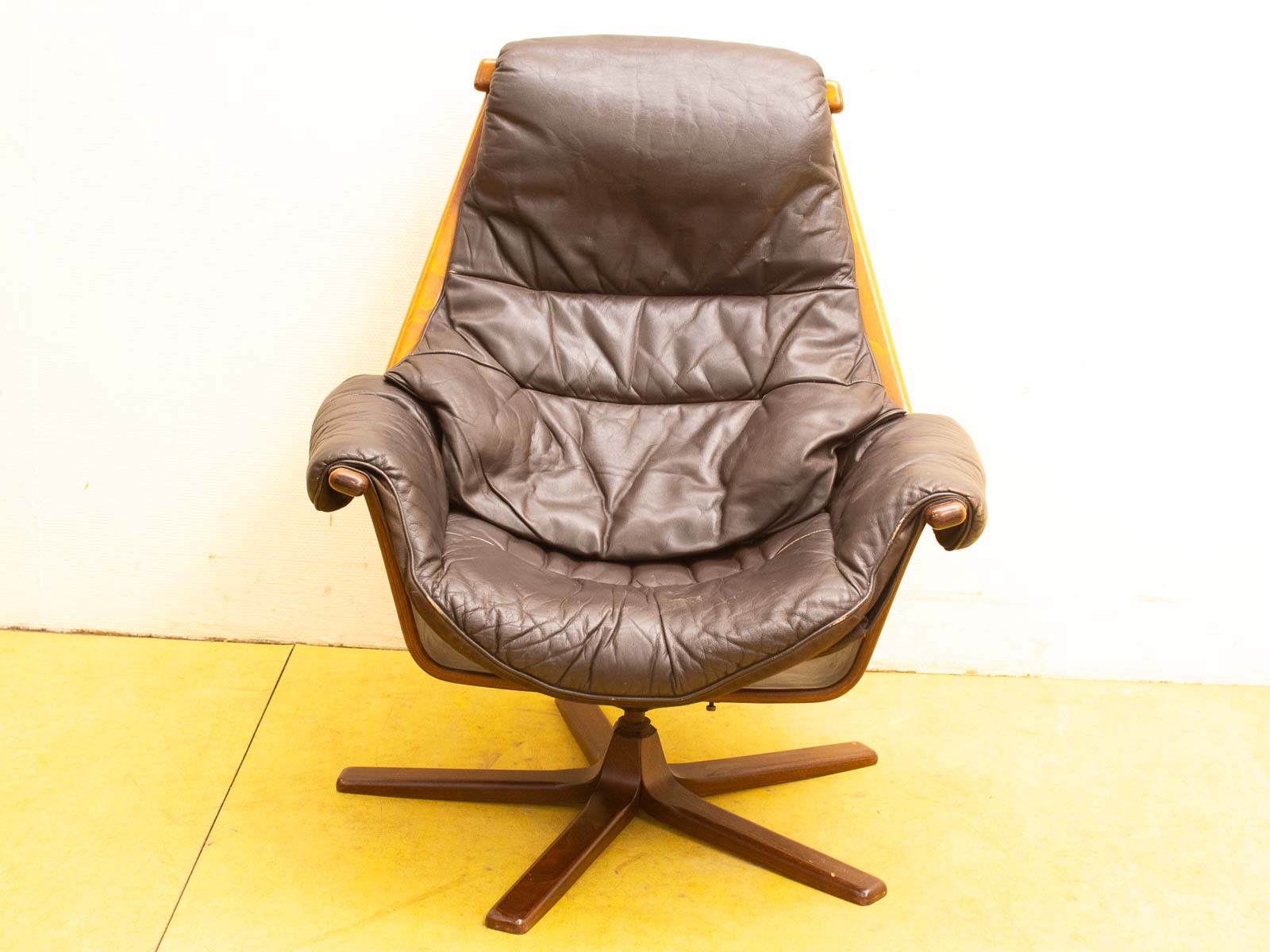 Stylish mid-century modern leather chair with a sleek wooden frame for contemporary interiors.