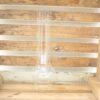 Clear glass laboratory flask on rustic wooden background, combining science and natural beauty.