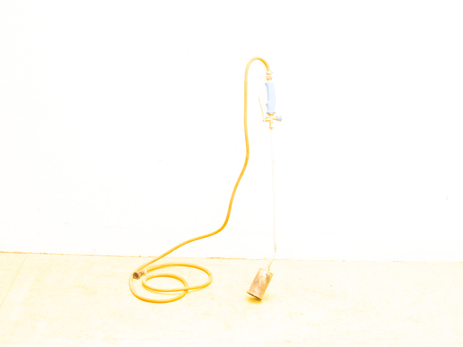 Versatile torch tool with flexible hose for controlled heating in gardening and construction tasks.