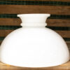 Elegant white ceramic bowl on wooden shelf with green textured background. Perfect for decor and function.