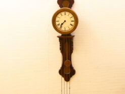 Elegant wooden wall clock with pendulums and Roman numerals, perfect for vintage decor.