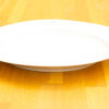 Elegant white oval serving platter on a warm wooden table, perfect for special occasions.