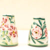 Charming ceramic vessels with vibrant floral designs, perfect for decoration or functional use.