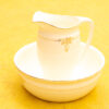 Elegant vintage ceramic pitcher and basin set with gold accents, perfect for decor or collection.