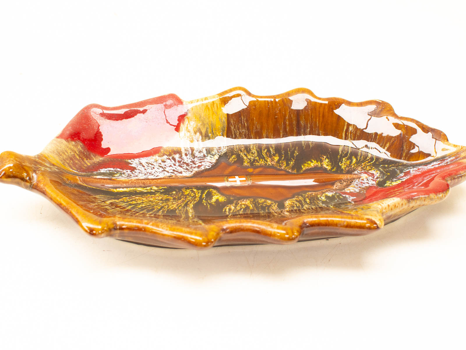 Handmade ceramic leaf-shaped dish in earthy tones, perfect for serving or decorative display.