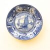 Elegant blue and white decorative plate showcasing a serene maritime scene with floral accents.