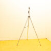 Stylish tripod on yellow floor in minimalistic space, perfect for photographers and videographers.