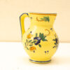 Charming yellow ceramic pitcher with floral designs, perfect for home decor and collectors.