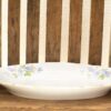 Elegant porcelain plate with blue floral design on rustic wooden surface.