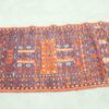 Vibrant vintage rug with geometric patterns in red, blue, and white, showcasing exceptional craftsmanship.