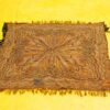 Vibrant vintage paisley textile with fringe on a bright yellow background, showcasing exquisite craftsmanship.