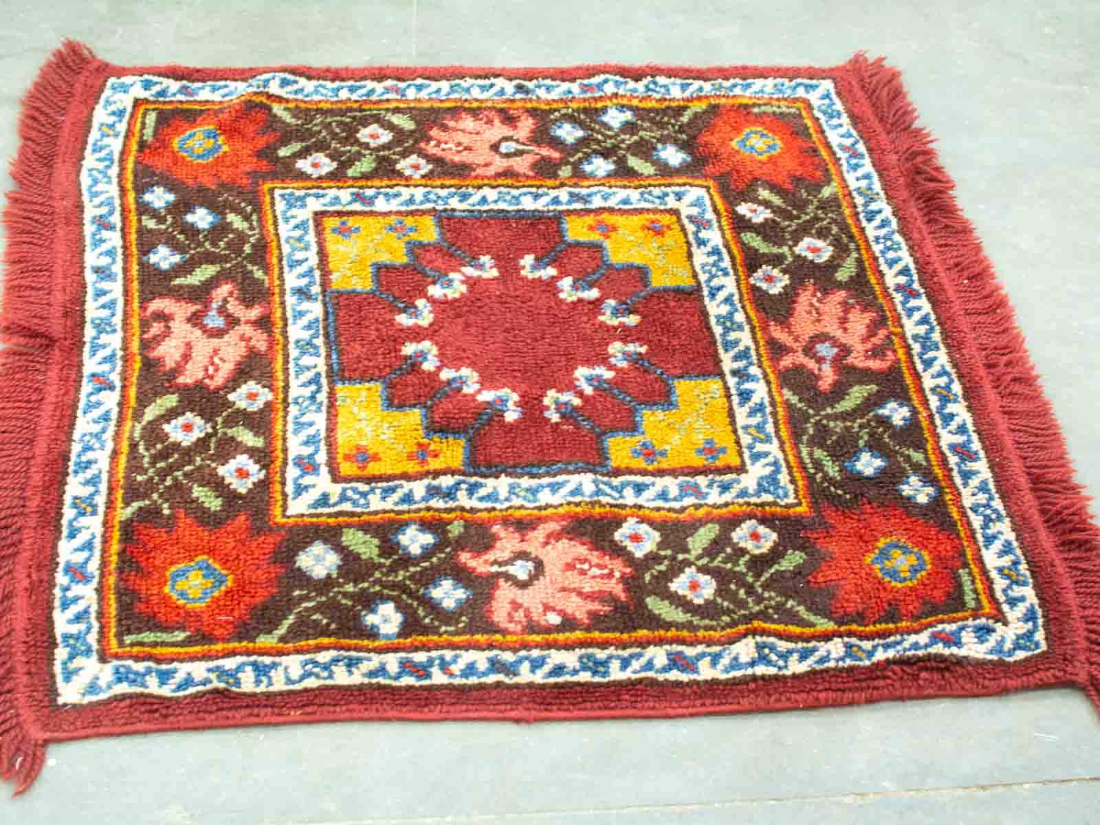 Vibrant maroon vintage rug with geometric and floral designs, adding warmth to any space.