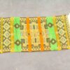Vibrant geometric woven textile with earthy tones and decorative fringes for stunning home décor.