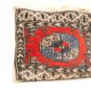 Vibrant vintage textile with red circular motif and geometric patterns, showcasing exceptional craftsmanship.