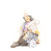 Vintage witch doll with pointed hat, mischievous grin, and colorful patchwork dress for Halloween decor.