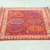 Vibrant vintage rug featuring intricate diamond patterns and rich, contrasting colors for stunning decor.