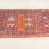 Traditional handwoven rug in deep red and blue with intricate geometric and floral patterns.