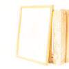 Minimalist vintage frame and rustic wooden crates in a bright, serene setting.