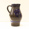 Elegant Hand-Painted Ceramic Jug with Vibrant Blue Motifs on a Glossy Black Surface