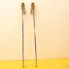 Lightweight blue, red, and white ski poles with ergonomic grips and adjustable straps for optimal performance.