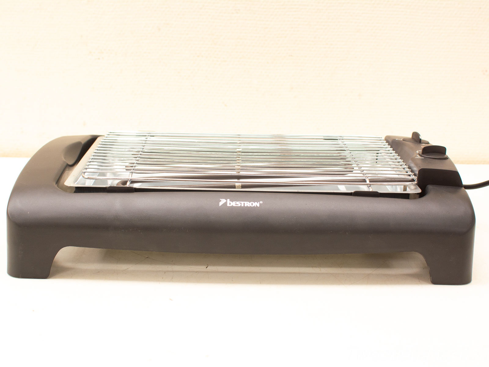 Compact electric grill for indoor use, featuring a sleek design and adjustable temperature control.