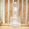 Elegant crystal decanter on rustic wooden background, symbolizing refined taste and sophistication.
