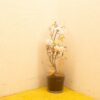 Elegant glass vase with soft artificial flowers on a cheerful yellow floor.