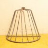 Vintage metal garden structure with conical design for plant protection and outdoor decor.