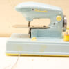 Vintage Malourette sewing machine in light blue with yellow thread, perfect for creative projects.