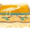 Handmade textile art featuring a stylized bird and vibrant floral motifs in a decorative rug design.
