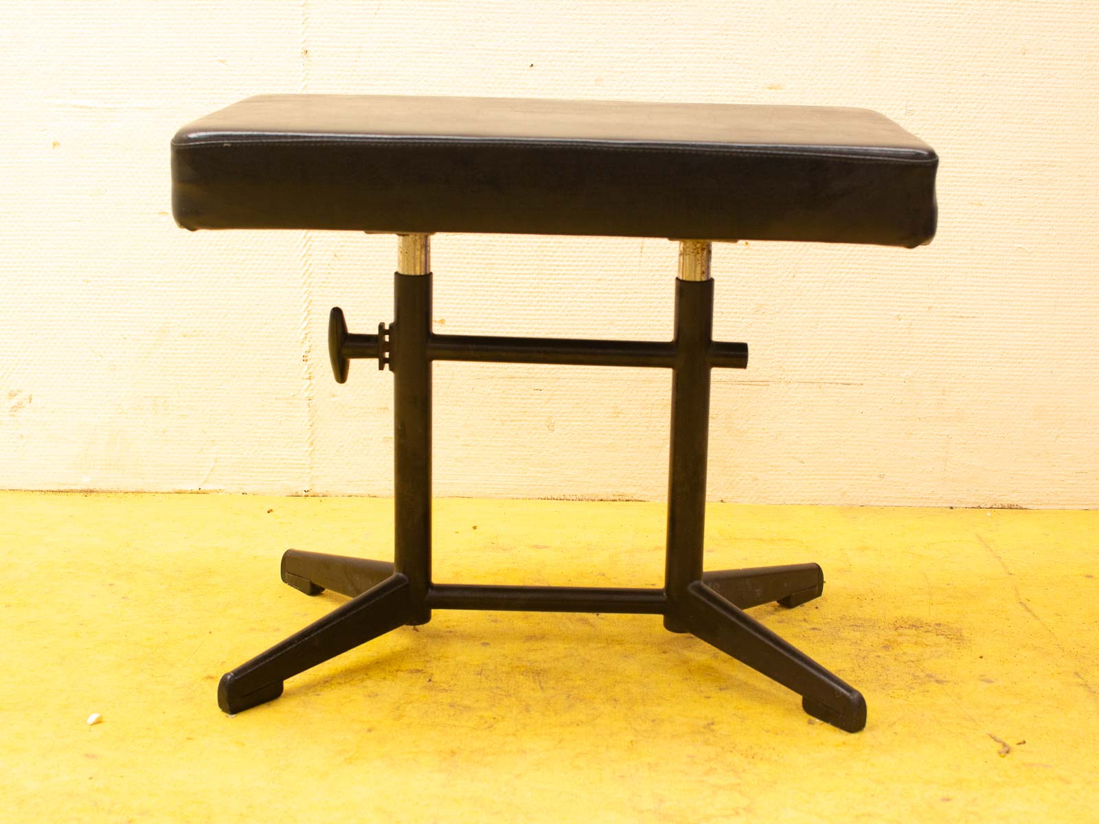 Stylish black bench with adjustable height, perfect for modern spaces like gyms and salons.