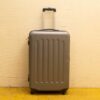 Sleek gray suitcase with wheels, designed for durability and easy travel maneuverability.