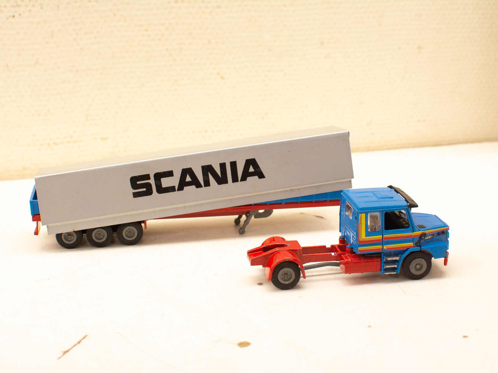 Vibrant Scania truck and trailer model, featuring detailed design and striking colors for collectors.