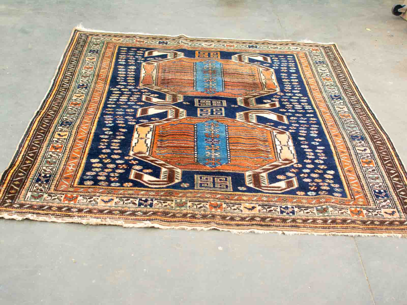 Colorful vintage rug with octagonal motifs and intricate patterns in rich blue and warm tones.
