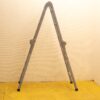 Vintage gray ladder against beige wall on vibrant yellow floor, perfect for any task.
