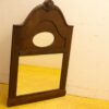 Elegant wooden mirror with intricate carvings and a decorative crest, perfect for any interior.